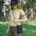 Vista di dettaglio di mini borsa a tracolla nera, stile outdoor casual con cinghia. - Nero