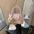 Vue détaillée du joli sac à bandoulière rose avec charm en peluche chiot et nœud mignon. - Avec Pendentif / Rose