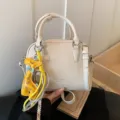 Chic white leather crossbody bag with cute giraffe pendant, elegant handbag for daily use. - Beige With Pendant