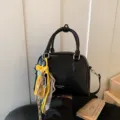 Black leather crossbody bag with chic giraffe charm, versatile small square purse for daily commute. - Black With Pendant