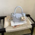 Borsa a secchiello chic in pelle azzurra con ciondolo cucciolo carino per l'uso quotidiano. - Con Ciondolo / Blu
