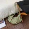 Detailed view of a light green plaid crossbody shoulder dumpling bag with a drawstring. - Green