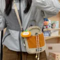 Detail view of a casual contrast-color crossbody phone bag with a cute fruit pendant. - Persimmon Kitten Pendant / Khaki
