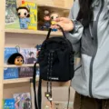 Detailed shot of a black casual crossbody phone bag featuring a secure drawstring closure. - No Pendant / Black