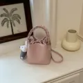 Schicke rosa Leder Eimer Tasche mit geflochtenem Griff und süßem Anhänger, Umhängetasche. - Anhänger-Stil / Rosa