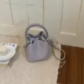 Detailaufnahme einer eleganten hellvioletten Beuteltasche mit geflochtenem Henkel. - Basisstil / Lila