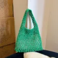 Green woven handbag detail view, showcasing intricate macrame mesh design and stylish underarm strap. - Green