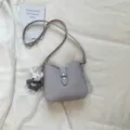 Minimalistische Damen Schultertasche lässige Pendler Handtasche stilvolle Ledertasche - Mit Puppenanhänger / Lila