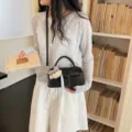 Schwarze Umhängetasche aus Lackleder für Damen, schicke kleine quadratische Tasche mit Bär. - Schwarz Mit Anhänger
