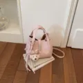 Bolso tipo cubo de cuero rosa para mujer, con asas superiores, correa para el hombro y dije de osito. - Rosa Con Colgante