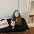 Bolso cubo marrón de piel con colgante de oso, elegante bolso de mano para mujer de uso diario. - Marrón con Colgante