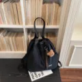 Stylish black nylon bucket backpack for women, casual multi-function shoulder and daily bag. - With Charm / Black