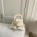 Bolso de mano acolchado en color crema con bonito dije de osito y cierre para mujeres chic. - Blanco con colgante