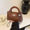 Brown woven mini handbag with top handle, flap closure, and stylish chain strap for women. - Brown
