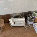 Bolso bandolera plateado para mujer, bolso elegante con dije de poni y lazo. - Plata Con Colgante