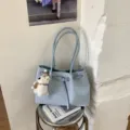 Light blue woven tote bag with buckle strap and cute bear pendant, stylish casual bucket bag. - Blue With Pendant