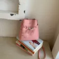 Sac seau en cuir rose pour femme, sac à bandoulière minimaliste élégant avec cordon. - Rose