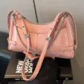Borsa a spalla rosa in pelle sottobraccio con eleganti cinturini a catena e fibbie alla moda. - Rosa