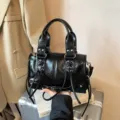 Schwarze glänzende Leder-Motorradhandtasche mit geflochtenen Schnüren und Nieten für Alltag. - Reguläre Passform / Schwarz