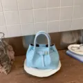 Light blue woven bucket bag for women, stylish summer handbag with crossbody strap and buckle. - No Pendant / Blue