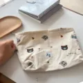 Detail view of the cute cat embroidered canvas makeup pouch, showcasing fine stitching and fabric. - Beige