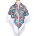 Detailweergave van de prachtige etnische bloemensjaal met blauwe, oranje rozen en franjes. - Wit
