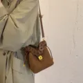 Borsa a secchiello in camoscio marrone da donna con manico intrecciato e chiusura in metallo. - Marrone scuro