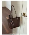 Gedetailleerd overzicht van een bruine geweven lederen tote bag met hanger in retro stijl. - Tote Bag (Met Hanger) / Koffie Met Ciondolo