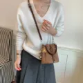 Brown suede drawstring bucket bag with stylish crossbody strap and floral charm. - With Pendant / Brown