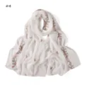 Detailed shot of delicate pink floral and bow embroidery on a lightweight white scarf. - White