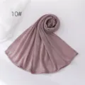 Detail view of a soft crinkled polyester scarf in dusty pink, elegant coiled fabric texture. - Dusty Pink