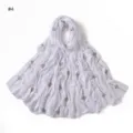 Detailed close-up view of white rhinestone clover line scarf fabric texture and sparkle design. - White