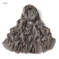 Close-up detail of soft crinkled slub cotton scarf with delicate fringe texture edge. - Taupe