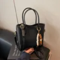 Schwarze Leder Handtasche für Damen, stilvolle retro Umhängetasche mit Perlenanhänger. - Schwarz