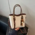 Damen braun und beige Farbblock Eimer Handtasche, lässige Pendler Umhängetasche mit Anhänger. - Weiß