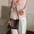 Sac à bandoulière en cuir tressé marron foncé, variante élégante sac seau cuir souple femme. - Avec Pendentif / Café