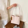 Sac seau bandoulière élégant en cuir tressé rose pour femme avec charm de perles chic. - Rose