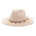 Detailopname van beige strooien fedora hoed met kleurrijke kralen en schelp touw decoratie. - Roze