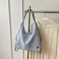 Light blue crinkled nylon tote bag with cute metal butterfly charms for women daily commute. - Blue