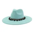 Close-up detail of light blue faux suede fedora hat featuring black pom-pom woven band. - Mint Green