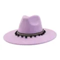 Close-up of lavender wide-brim fedora hat featuring black-white woven band and pom-poms. - Lavender