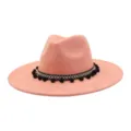 Close-up of pink faux suede jazz hat featuring ethnic black white band and cute black pom poms. - Rose Quartz
