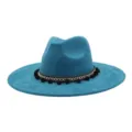 Close-up of blue faux suede fedora hat detail featuring black pom-pom ethnic decorative woven band. - Peacock Dark Blue