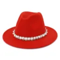 Detail shot of the red wool felt fedora hat featuring an elegant pearl and bead trim band. - Orange