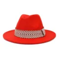 Detail van rode wollen vilt fedora hoed met stijlvolle bruin en wit geweven band. - 58cm / Oranje