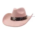 Close-up detail of pink suede cowboy hat featuring brown studded band and metal skull accent. - Pink