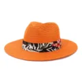 Detailansicht eines orangefarbenen Strohhutes mit schwarzem tropischen Blumenband für Strand. - 58cm / Orange