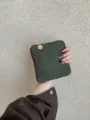 Detail shot of dark green fabric embroidered small pouch with retro circular pattern zipper. - S / Green