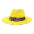 Close-up detail of a vibrant yellow straw fedora hat featuring a stylish paisley printed band. - Yellow