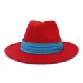 Red wool fedora hat featuring blue pleated band, closeup detail of classic fashion jazz hat. - Red